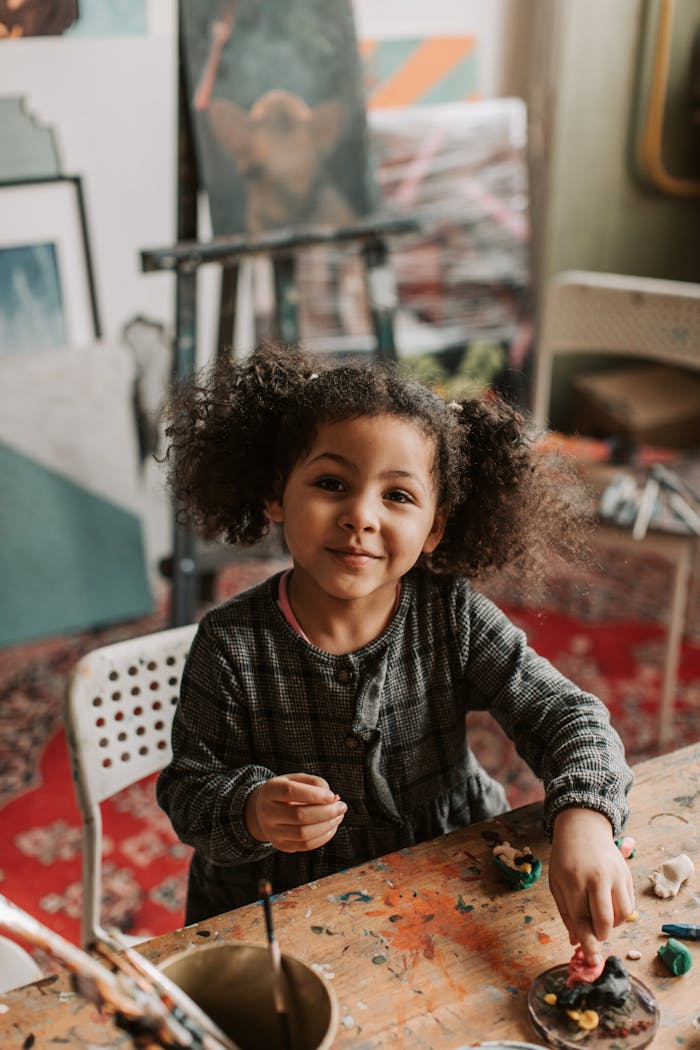 Adorable child enjoying a creative session with clay in a vibrant art studio.